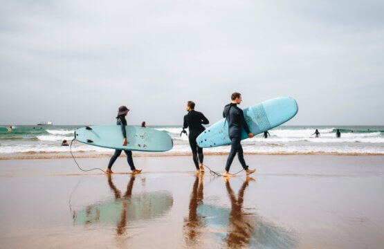 Tourists and surfers on the beach of Anza Agadir