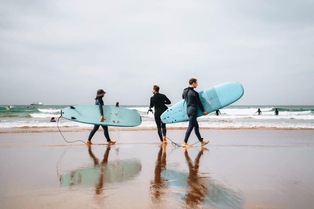 Tourists and surfers on the beach of Anza Agadir